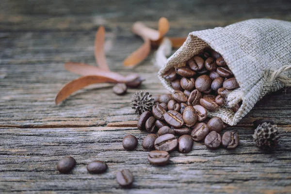 Saco de arpillera de granos de café sobre fondo de madera vieja — Foto de Stock