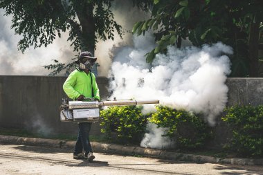 Sivrisinektehlikeli kontrol etmek için fogger makinesi kullanan adam 