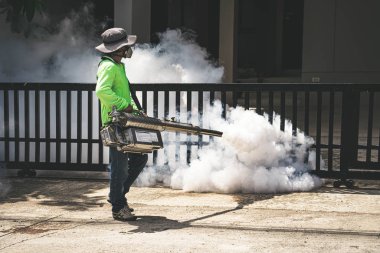 Sivrisinektehlikeli kontrol etmek için fogger makinesi kullanan adam 