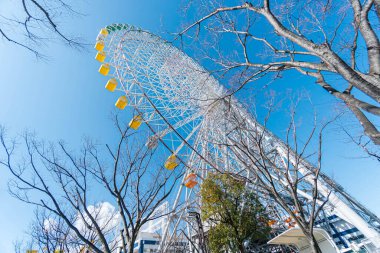 Tempozan giant ferris wheel in Osaka, Japan with  bright blue sky clipart