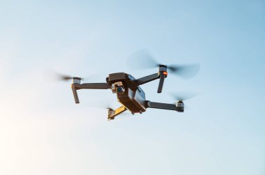 Remote controlled copter with digital camera on sky background. Closeup. New tool for aerial photo and video