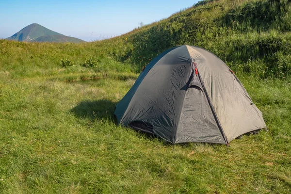 Zelený turistický stan v táboře mezi loukami v horách.Příroda pozadí — Stock fotografie