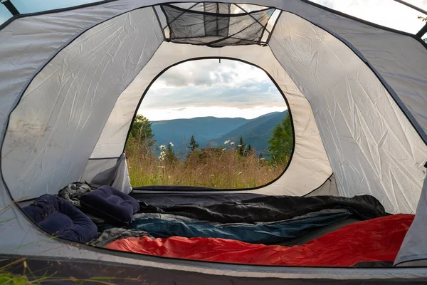 Pohled z turistického stanu na horách, louce, květinách, časně ráno, když vychází slunce. turistický stan — Stock fotografie