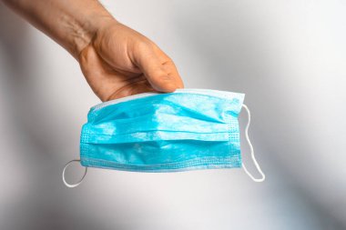 Koruyucu yüz maskesi elinde. Cerrahi maske. Tıbbi maske ve korona virüs koruması.