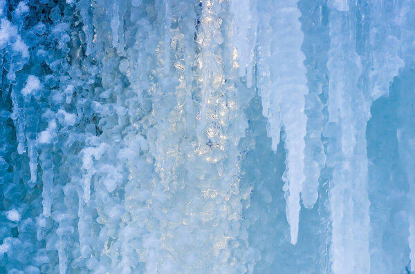 beautiful blue ice and frozen icicles , closeup, winter background