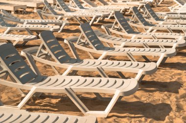 Kumsalda güneşlenenler, yaz mevsiminin ılık sabahları için kumun üzerinde dururlar.