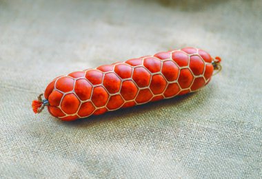 Yapay kabuklu sosis, kaba kumaşla kaplı bir masanın üzerinde duruyor.