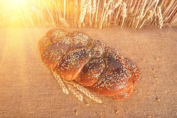 小麦畑と太陽を背景にテーブルの上にゴマとケシのパン — ストック写真