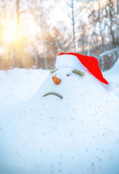 森の中の春を見越して 悲しい雪のドリフト 雪だるまは 暖かい光線が彼に選ばれているように見えています 悲しみの顔の形をした雪男が春に姿を消すのを待っている — ストック写真