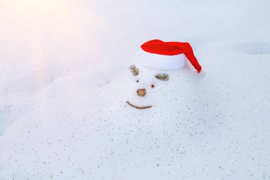 Neşeli kar yığını, kardan adam, Noel şapkasıyla, karlı bir kış ormanında Noel tatili bekleyerek.