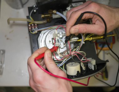 Teknisyen coffeemachine sensörünün direnci ölçer. 
