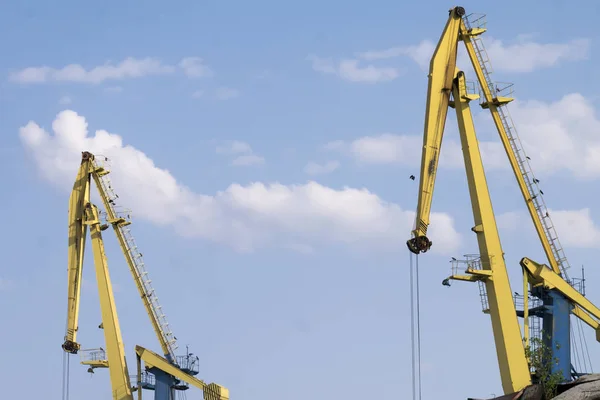 Gelbe Marinefrachtkräne gegen blauen Himmel. — Stockfoto