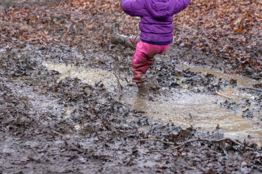 Genç çocuklar bir çamur birikintisinde oyun