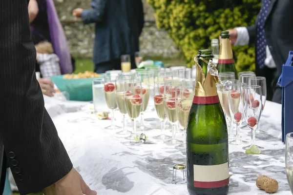 Bruiloft gasten drinken frambozen bellini champagne cocktails in een outdoor setting — Stockfoto