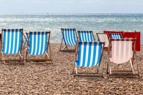 Colourful striped deck chairs on Brighton beach, England