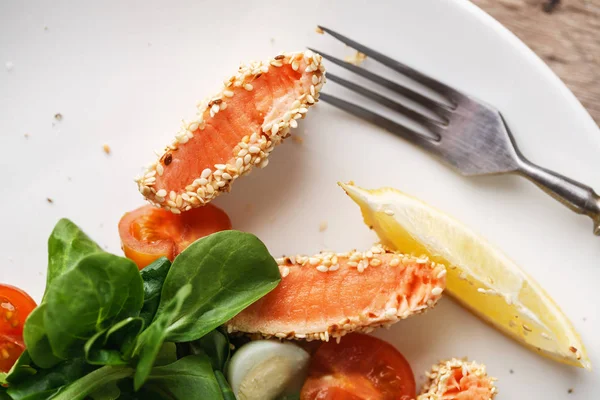 Salade de saumon grillée aux graines de sésame, tomates cerises et oeuf de caille sur table en bois — Photo