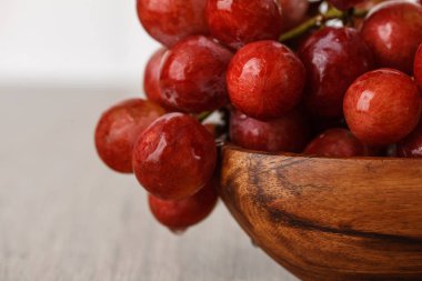 ahşap bir fincan kırmızı üzüm demet
