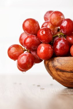 ahşap bir fincan kırmızı üzüm demet