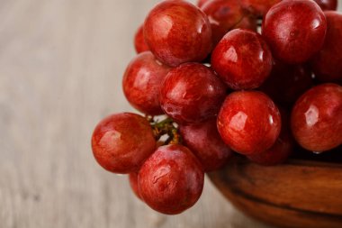 ahşap bir fincan kırmızı üzüm demet