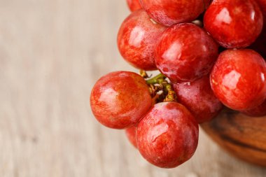 ahşap bir fincan kırmızı üzüm demet