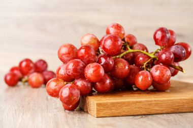 ahşap masa üstünde kırmızı üzüm