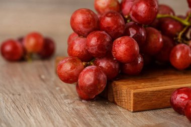 ahşap masa üstünde kırmızı üzüm