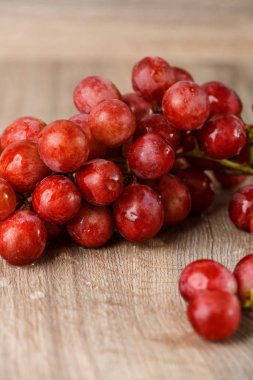 ahşap masa üstünde kırmızı üzüm