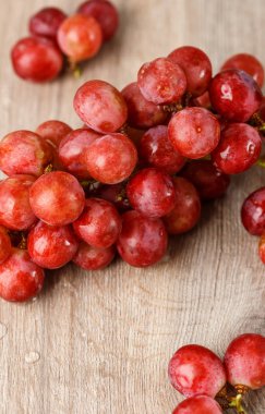 ahşap masa üstünde kırmızı üzüm