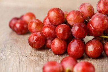 ahşap masa üstünde kırmızı üzüm