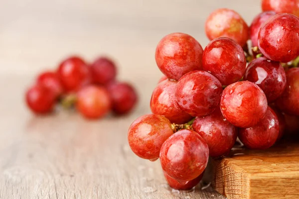 ahşap masa üstünde kırmızı üzüm