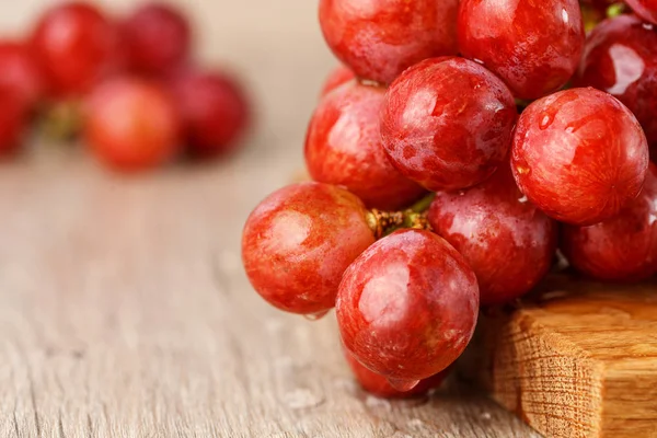 ahşap masa üstünde kırmızı üzüm