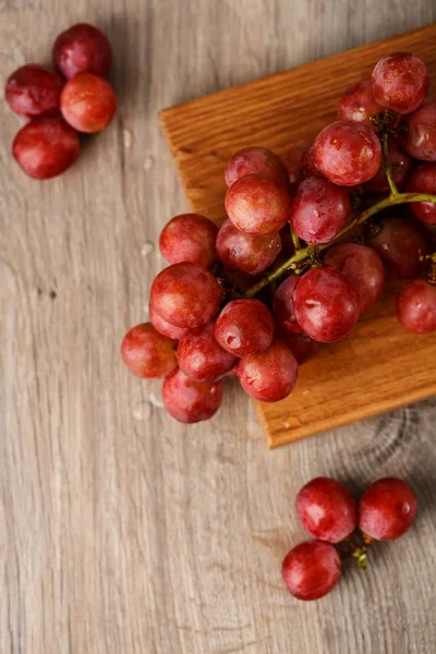 Red grapes on wooden table — Stock Photo, Image