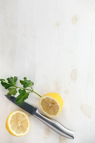 one lemon cut in half with metal knife