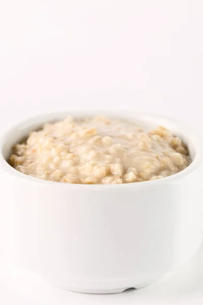 Desayuno: avena gachas en tazón blanco sobre fondo blanco. Aislado — Foto de Stock