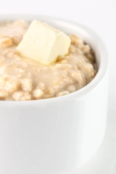 Frühstück: Haferbrei mit Butter in weißer Schüssel auf weißem Hintergrund. isoliert — Stockfoto