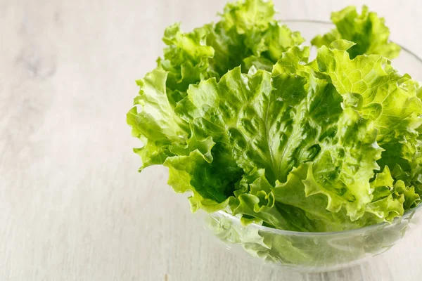 Lettuce leaves in glass bowl on white background. Closeup — Stock Photo, Image