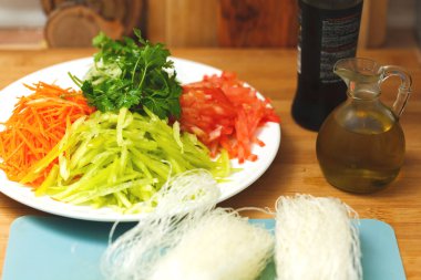 Sebzeleri dilimlere ayırır. Havuç, biber, domates ve yeşillik. Salata hazırlanıyor.