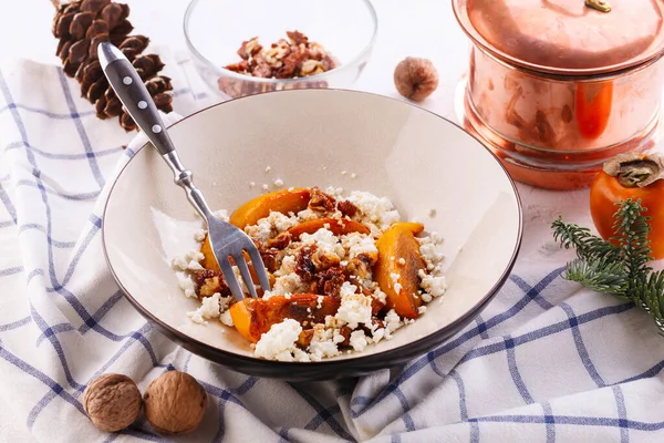 Winter dessert. caramelized persimmon with walnuts and cottage cheese