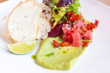 Avokado, marul, güneşte kurutulmuş domates ve ekmek kızartmalı ton balığı.