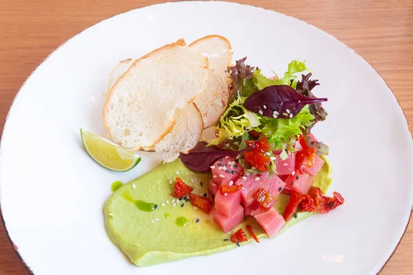 Тунець Тартар з авокадо, салатом, сушеними помідорами та хлібними чіпсами — стокове фото
