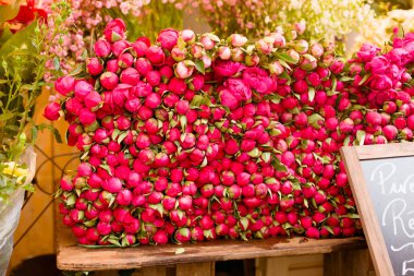 Çiçekçinin masasındaki pembe şakayıklar