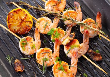 Şişte ızgara karides. Baharatlı, otlu ve limonlu ızgara deniz ürünleri. Lezzetli karides. Izgara yap. Demir ızgara. Kapat.