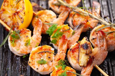 Şişte ızgara karides. Baharatlı, otlu ve limonlu ızgara deniz ürünleri. Lezzetli karides. Izgara yap. Demir ızgara. Kapat.