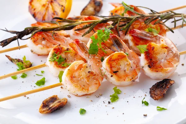 Grilled shrimp on skewers. Grilled seafood on skewers with spices, herbs and lemon. delicious prawn. White plate. White background — Stock Photo, Image