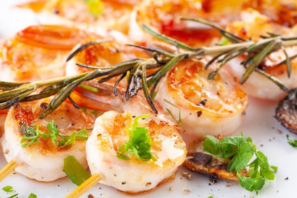 Grilled shrimp on skewers. Grilled seafood on skewers with spices, herbs and lemon. delicious prawn. White plate. close up — Stock Photo, Image