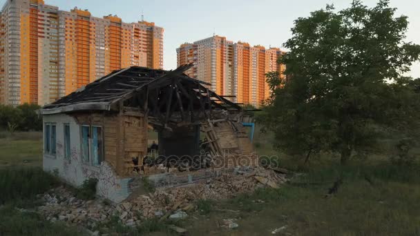 孤独な古い台無しにされた家は、新築高層マンションの近くに立っています。航空写真ビュー — ストック動画