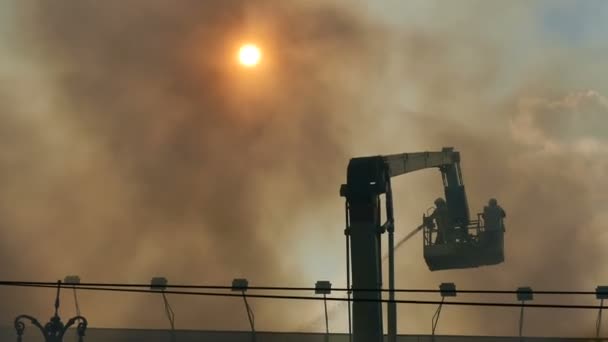 Пожежники воюють з вогнем. Густий дим піднімається над будівлею — стокове відео