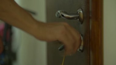 Elinde anahtarla kapıyı kilitlemek ya da açmak.