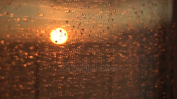 После дождя вода капает на оконное стекло. Небо с облаками и солнцем на фоне . — стоковое видео