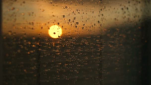 Na szyby krople wody po deszczu. Niebo z chmur i słońca na tle. — Wideo stockowe